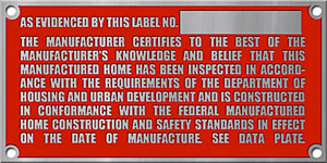 A photo of a HUD certification label (red tag with silver color text).