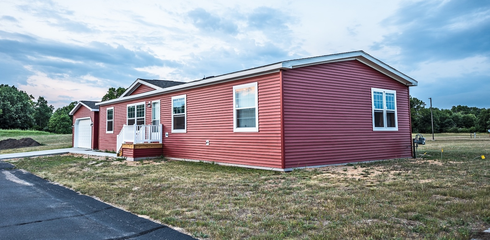 Photo of the exterior of a manufactured home with red siding.